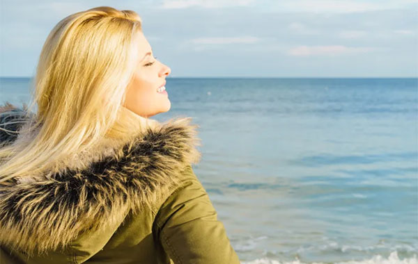 Femme au soleil au bord de la mer plein de vitamine D