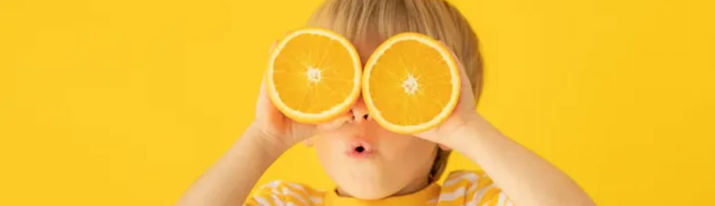 Enfant qui regarde dans deux citrons